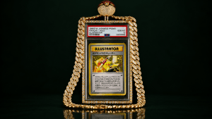 Gold-plated pendant necklace featuring a framed Pikachu Illustrator card on a dark background with a diamond-studded chain.