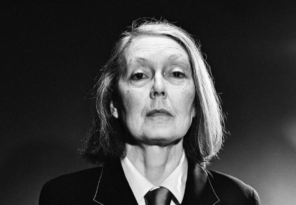 Black-and-white portrait of a serious older woman in a suit, looking straight ahead.